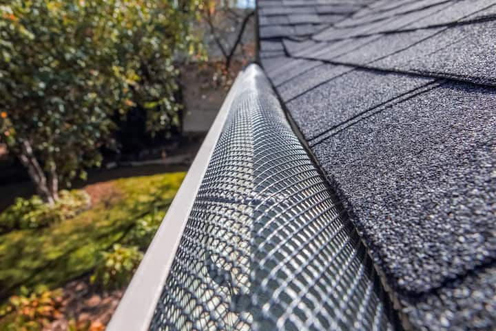 A contractor demonstrating the effectiveness of a gutter guard to a potential client in San Antonio